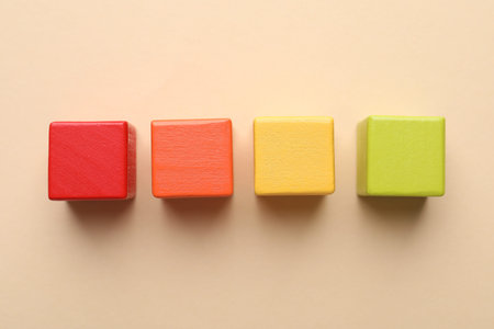 Colorful cubes on beige background, flat lay