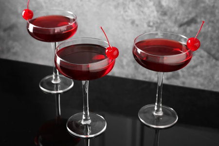 Glasses of tasty cocktails with garnish on mirror surface, closeupの写真素材