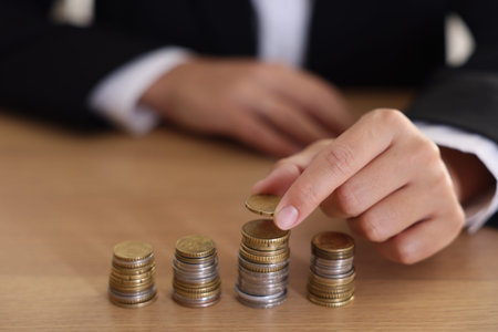 Woman counting coins at wooden table indoors, selective focus