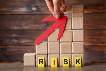 Risk. Woman holding red arrow near stacked wooden cubes at table, closeup