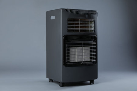 One electric heater on gray background. Domestic appliance