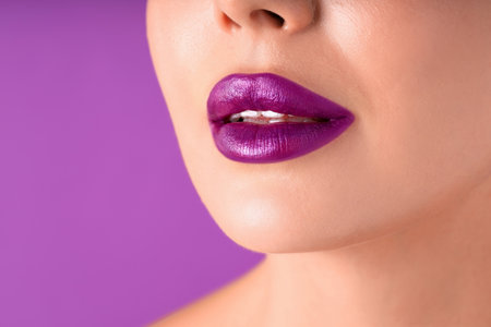 Woman with bright lipstick on purple background, macro viewの写真素材