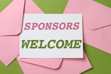 Paper with phrase Sponsors Welcome and envelopes on green background, top viewの写真素材