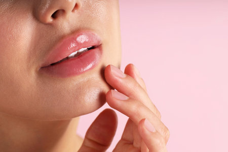 Woman with beautiful lips on pink background, macro view. Space for textの写真素材