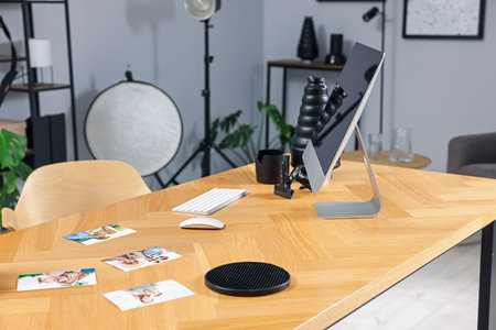 Pictures and computer on wooden table in studio