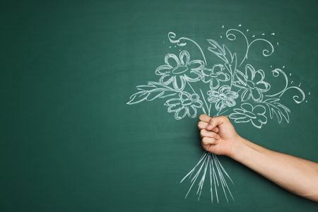 Happy teacher's day. Man near chalkboard with drawn bouquet of flowers, closeup. Space for textの写真素材
