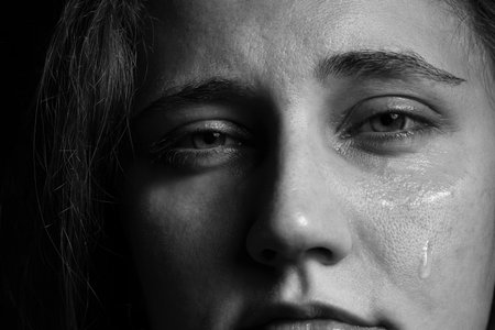 Sad woman crying on dark background, closeup. Black and white effectの写真素材