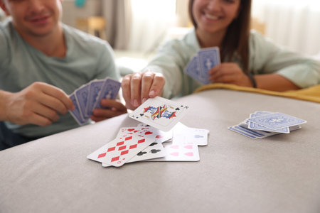 People playing cards at home, selective focus