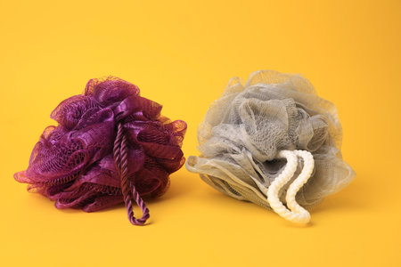 Colorful shower puffs on yellow background. Personal hygieneの写真素材