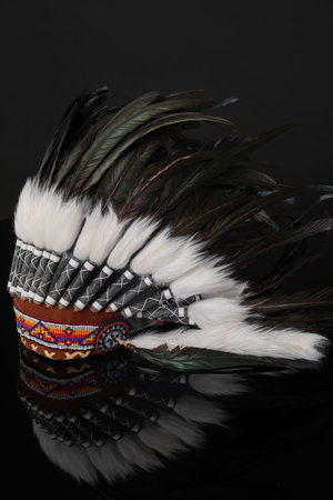 Traditional warbonnet (Native American chief headdress) on black mirror surface