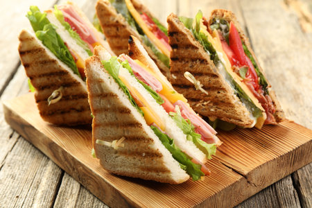 Tasty sandwiches with different fillings on wooden table, closeupの写真素材