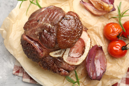 Tasty cut beef steak served with rosemary, garlic and tomatoes on gray textured table, top viewの写真素材