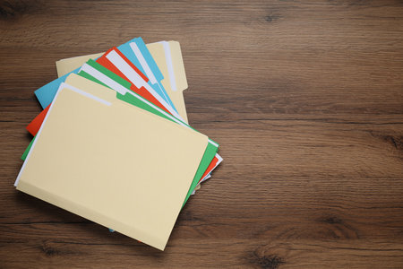 Many documents in folders on wooden table, top view. Space for textの写真素材