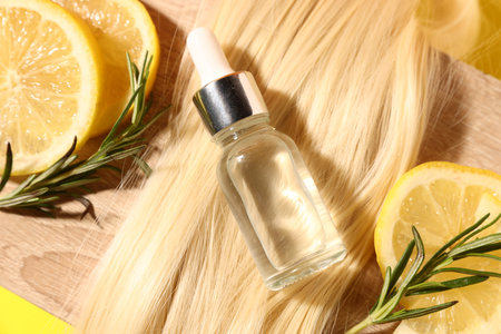 Hair lock, cosmetic product, rosemary and lemon slices on wooden background, flat layの写真素材