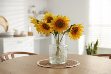 Beautiful sunflowers in vase on wooden table at homeの写真素材
