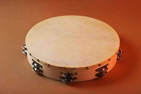 Tambourine on brown background, closeup. Traditional musical instrumentの写真素材