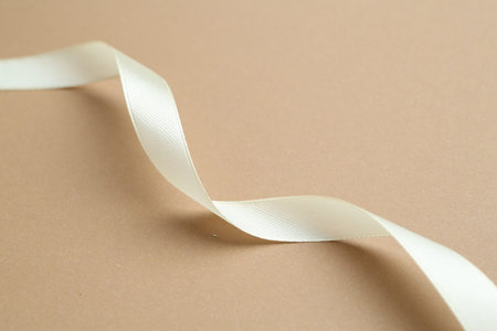 Beautiful ribbon on beige background, closeup viewの写真素材