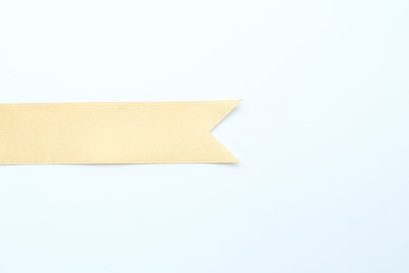 Beautiful yellow ribbon on white background, top view. Space for textの写真素材
