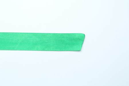 Beautiful light green ribbon on white background, top view. Space for textの写真素材