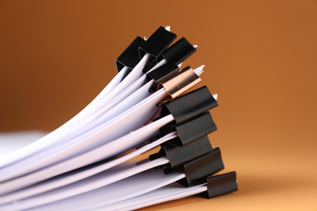 Many documents with binder clips on brown background, closeupの写真素材