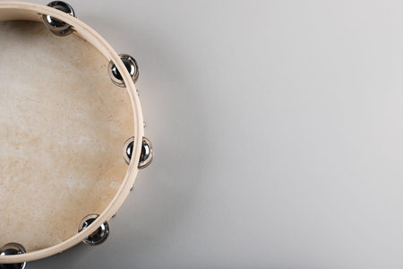 Tambourine on light background, top view. Space for text