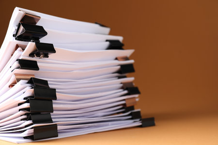 Many documents with binder clips on brown background, closeup. Space for textの写真素材
