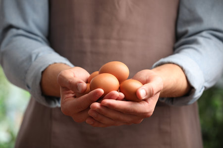 Man with many raw chicken eggs outdoors, closeupの写真素材