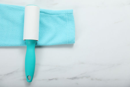 Lint roller and cloth on white marble table, top view. Space for textの写真素材