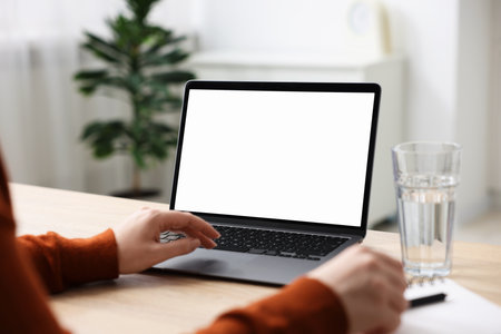 Woman working with laptop at wooden table indoors, closeup. Mockup for designの写真素材