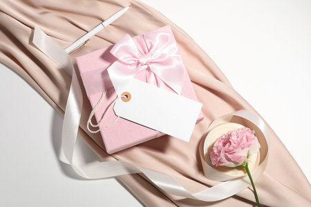 Blank card, gift box, pen, ribbon, cloth and beautiful rose on white background, top viewの写真素材