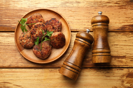 Salt and pepper shakers, meatballs on wooden table, flat layの写真素材