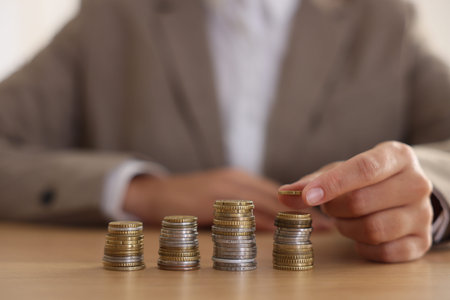 Woman counting coins at wooden table indoors, selective focus