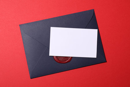 Blank card and envelope on red background, top viewの写真素材