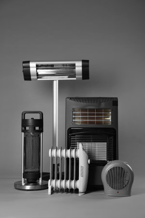 Different types of electric heaters on gray backgroundの写真素材