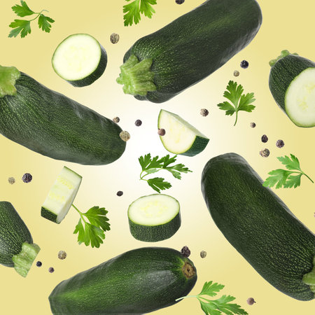 Fresh zucchini and parsley falling against color backgroundの写真素材