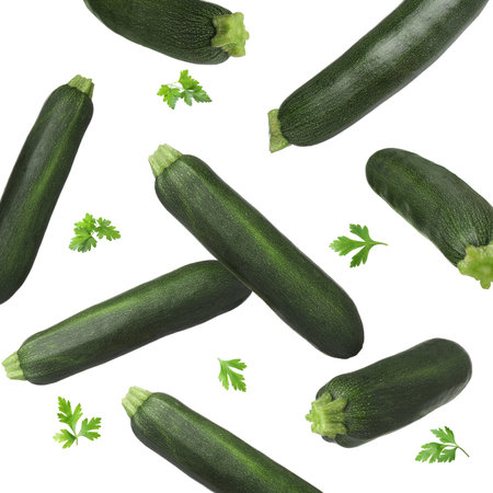 Fresh zucchini and parsley falling against white backgroundの写真素材