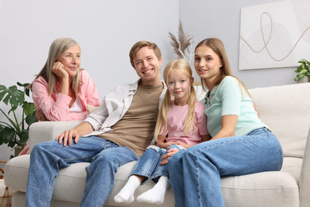 Senior woman with her son's family on sofa at home