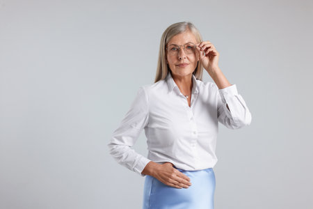 Professional woman in glasses on light gray background, space for textの写真素材
