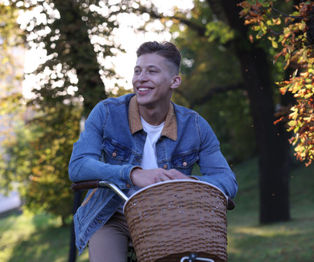 Happy man riding bicycle in park on sunny dayの写真素材