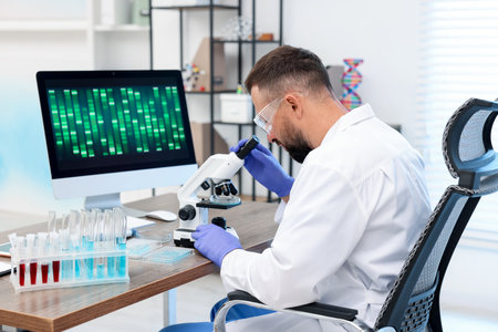 Research in genetics. Scientist working with microscope at table in laboratoryの写真素材