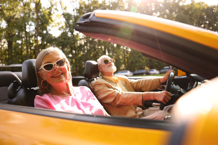 Senior couple enjoying cabriolet ride in city, selective focusの写真素材