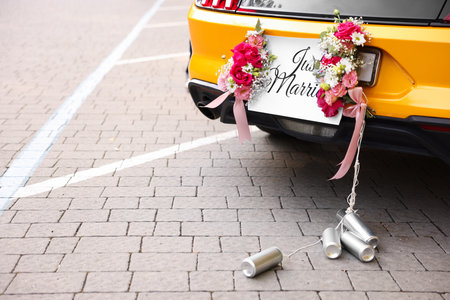 Wedding car. Cabriolet decorated with Just Married card, beautiful flowers and tin cans outdoors, closeup. Space for textの写真素材