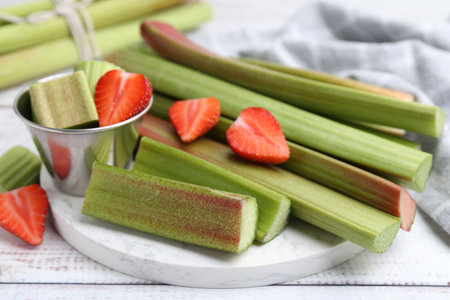 Rhubarb stalks and strawberries on white table, closeupの写真素材