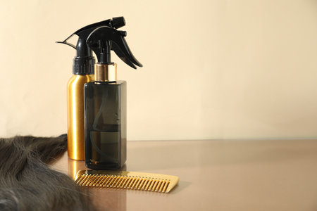 Hair lock, cosmetic products and comb on beige background. Space for textの写真素材