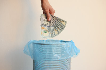 Man throwing dollar banknotes into trash bin on white background, closeupの写真素材