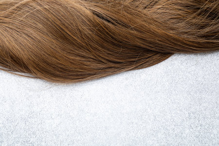 Beautiful hair strand on light background, top view. Space for textの写真素材