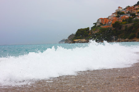 Beautiful view of sea with waves and coastal cityの写真素材