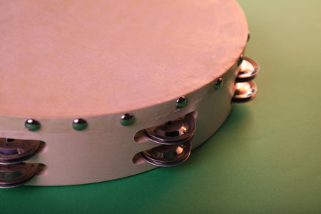 Tambourine on green background, closeup. Traditional musical instrumentの写真素材