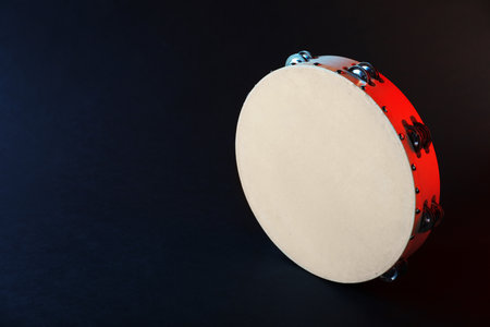 Tambourine in color light on black backgroundの写真素材