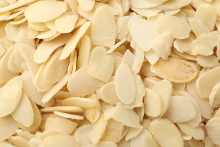 Fresh almond flakes as background, top viewの写真素材